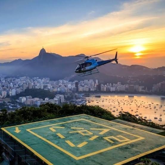 Helikopter vliegt over Rio de Janeiro bij zonsondergang, met de Corcovado op de achtergrond